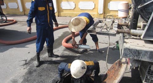 Công nhân hút bể phốt lắp ống vào bể chứa